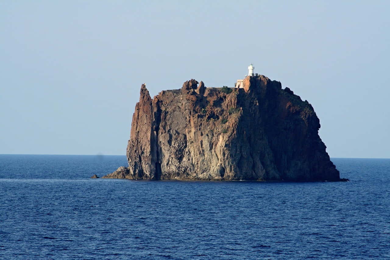 Strombolicchio Lighthouse, perched atop a volcanic islet off the coast of Stromboli, Italy.