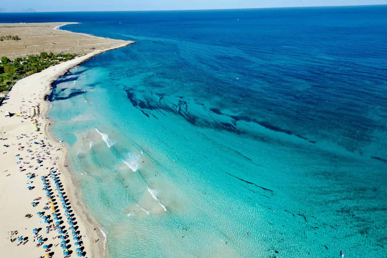 People relaxing on San Vito Lo Capo beach in Trapani, Italy