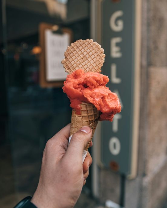 a hand holding a gelato ice cream in Rome