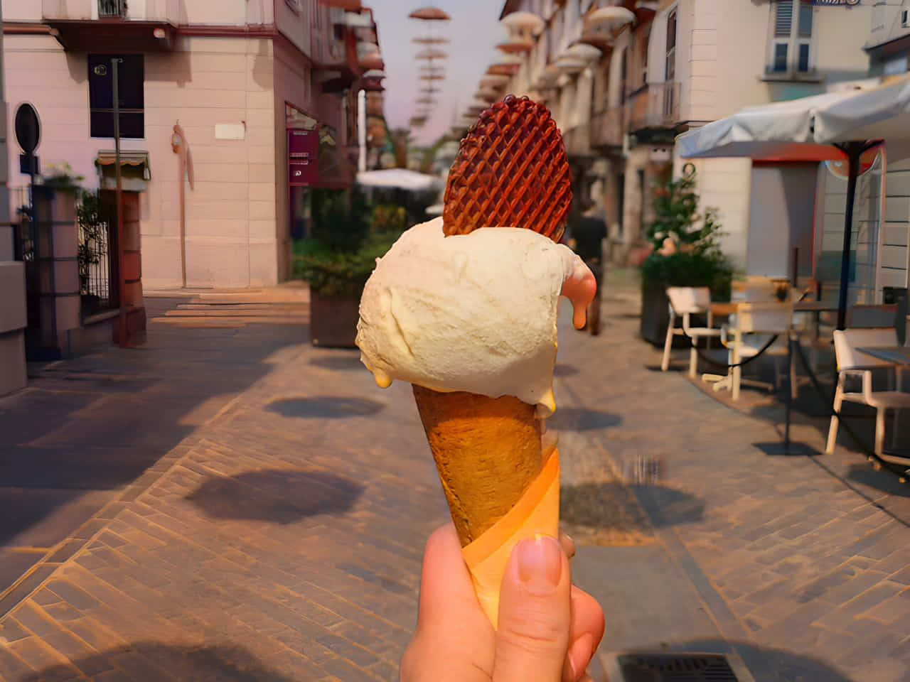 a hand holding a gelato ice cream near Giolitti gelato shop in Rome