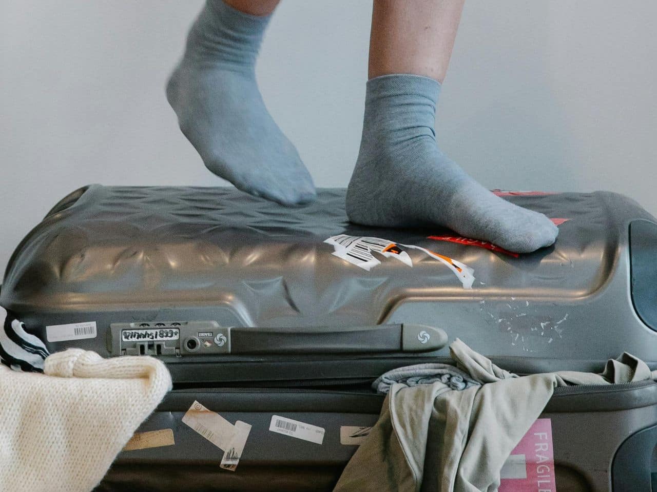 An overpacked travel bag with clothes read this guide to avoid these common packing mistakes