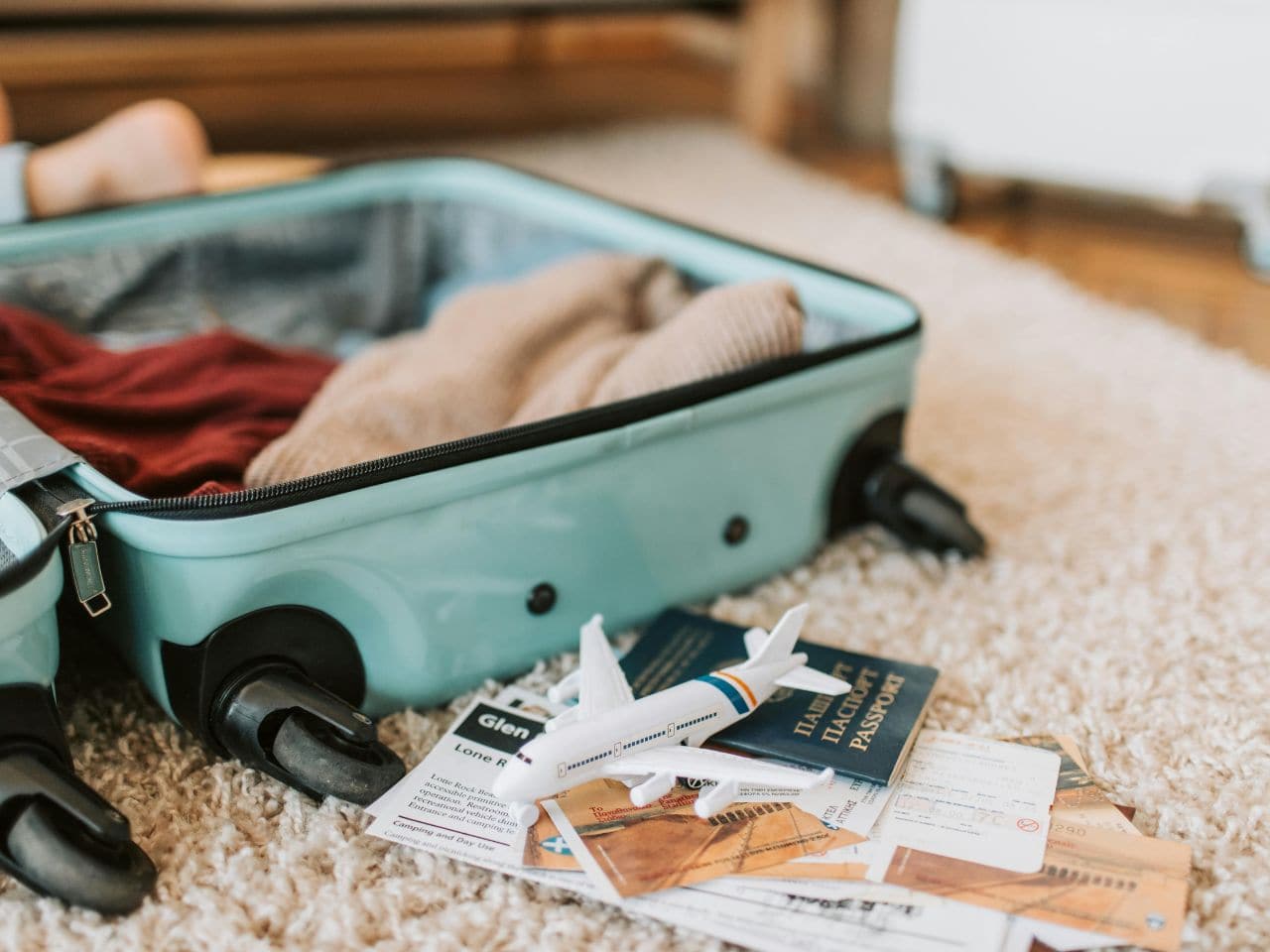 a travel bag and passport read this guide to avoid common packing mistakes