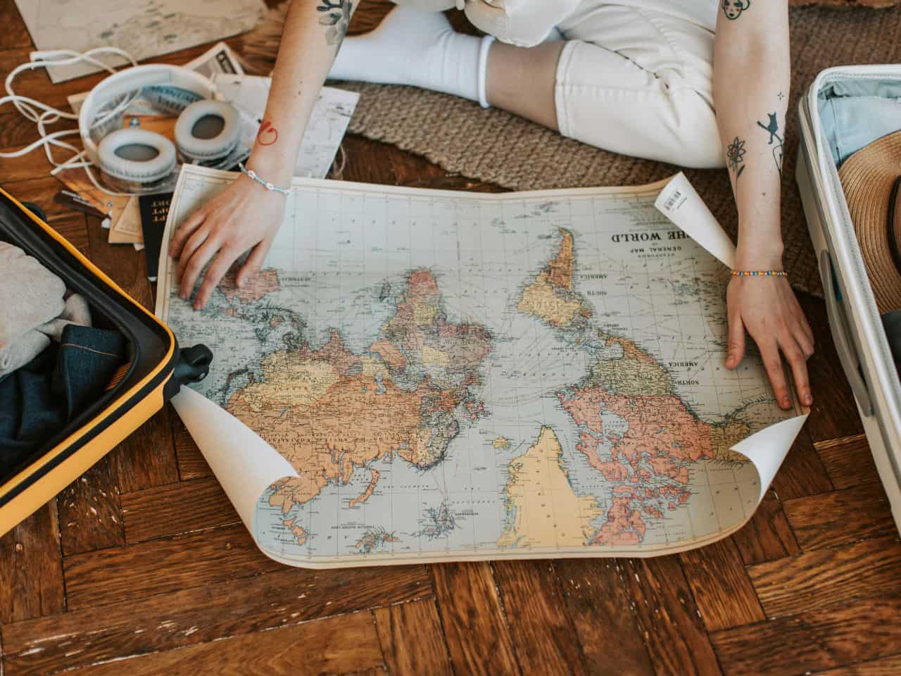 a girl looking at a world map to avoid some common packing mistakes before traveling