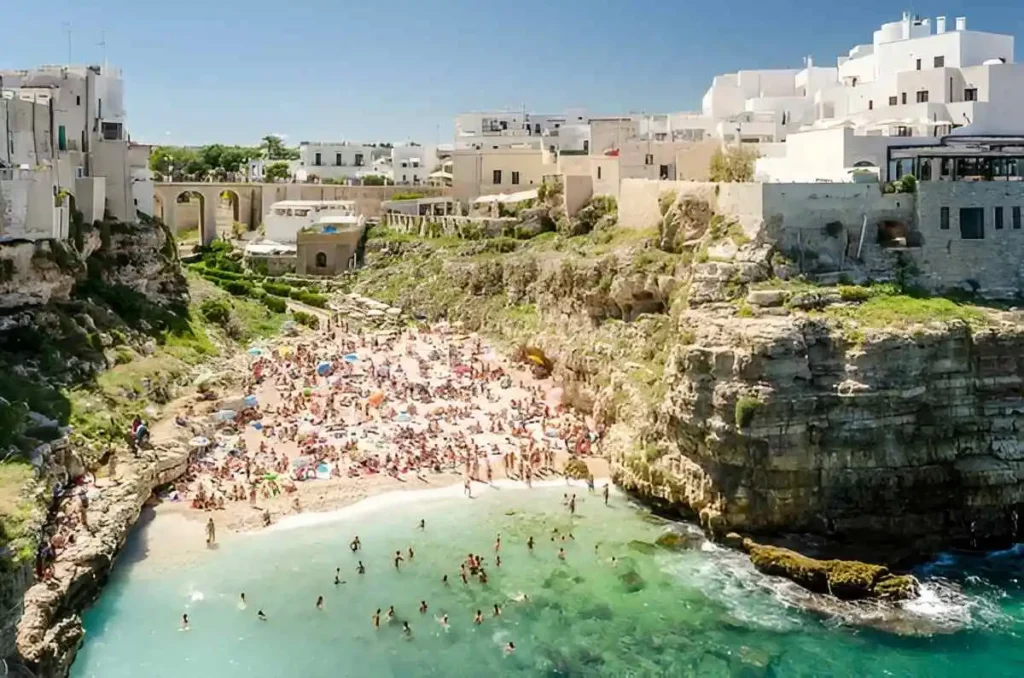 People soaking between the dramatic cliff in lama monachile beach in Puglia