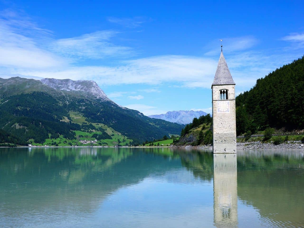 image features the 14th-century bell tower rising from the waters of Lake Resia