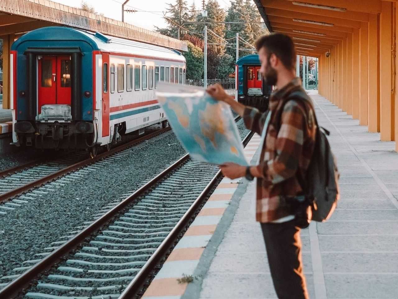 Traveler Checking a map in a European train station and recalling Europe Travel Tips