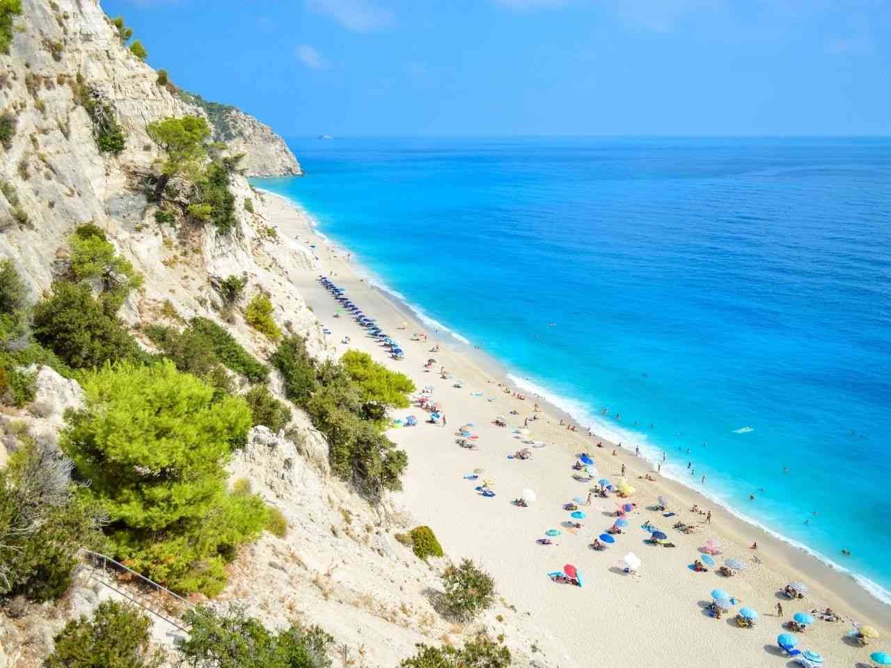 People relaxing on Egremni beach in Greece citing summer Europe vibe